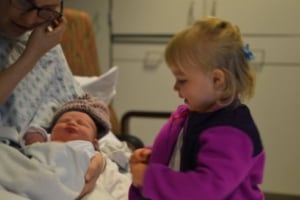 little girl meeting new baby