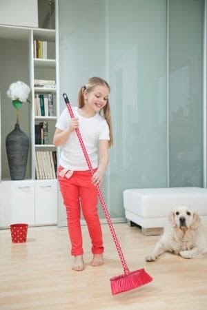 young girl sweeping and smiling