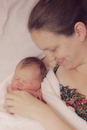 mother smiling at newborn baby