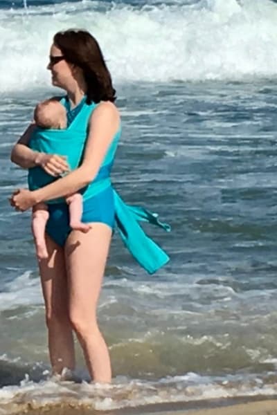 woman at beach wearing baby