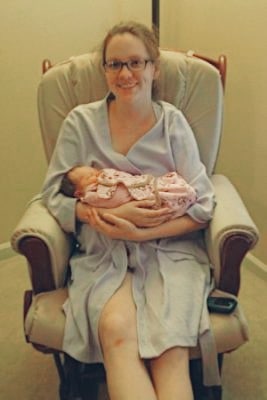 New First time Mother with newborn baby in her arms in a rocking chair