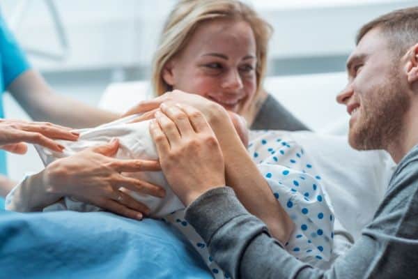 woman-with-newborn-and-husband-supported-by-doula