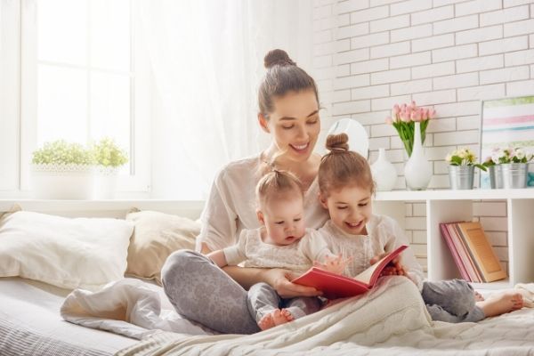 mother-reading-to-kids-in-bed