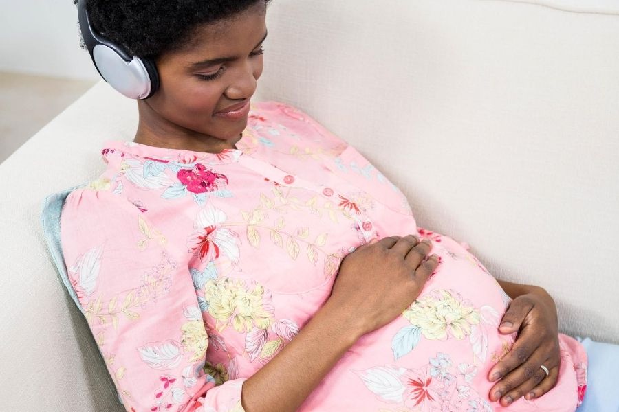 pregnant woman with headphones relaxing