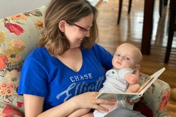 mother reading book about diaper changes to baby