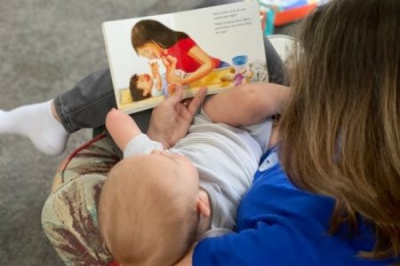 mother Reading diaper changing book to baby