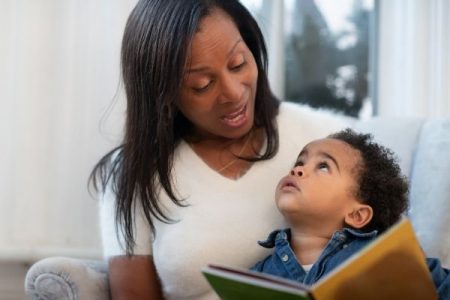 mother looking down to toddler while reading to him