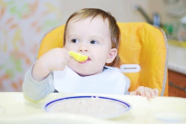 baby eating rice cereal with spoon