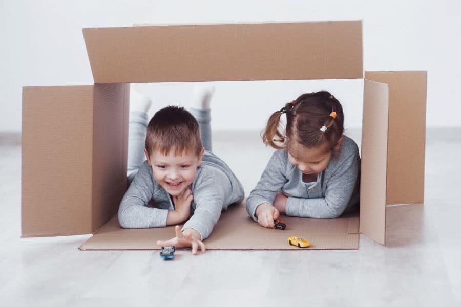 kids playing in cardboard box with toy cars