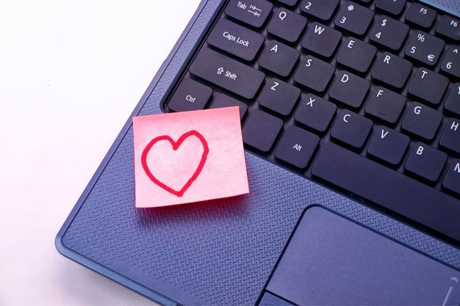 sticky note with little heart drawn on it stuck on laptop to announce pregnancy to husband