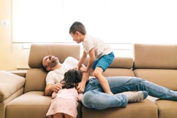 Dad playing on couch with kids