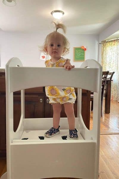 18 month girl standing in Little Partners Learning Tower at highest step height