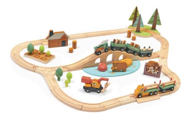 Train set with logging trucks, a little cabin, and pine trees
